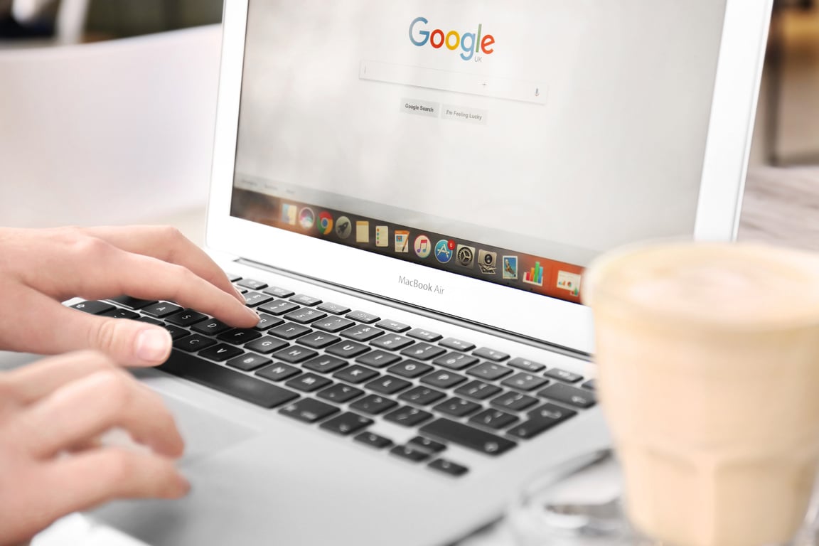  Woman Using Laptop with Google on Screen in Cafe